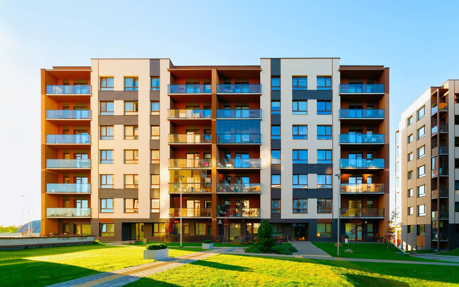 Modern apartment building with balconies and colorful facades under a blue sky