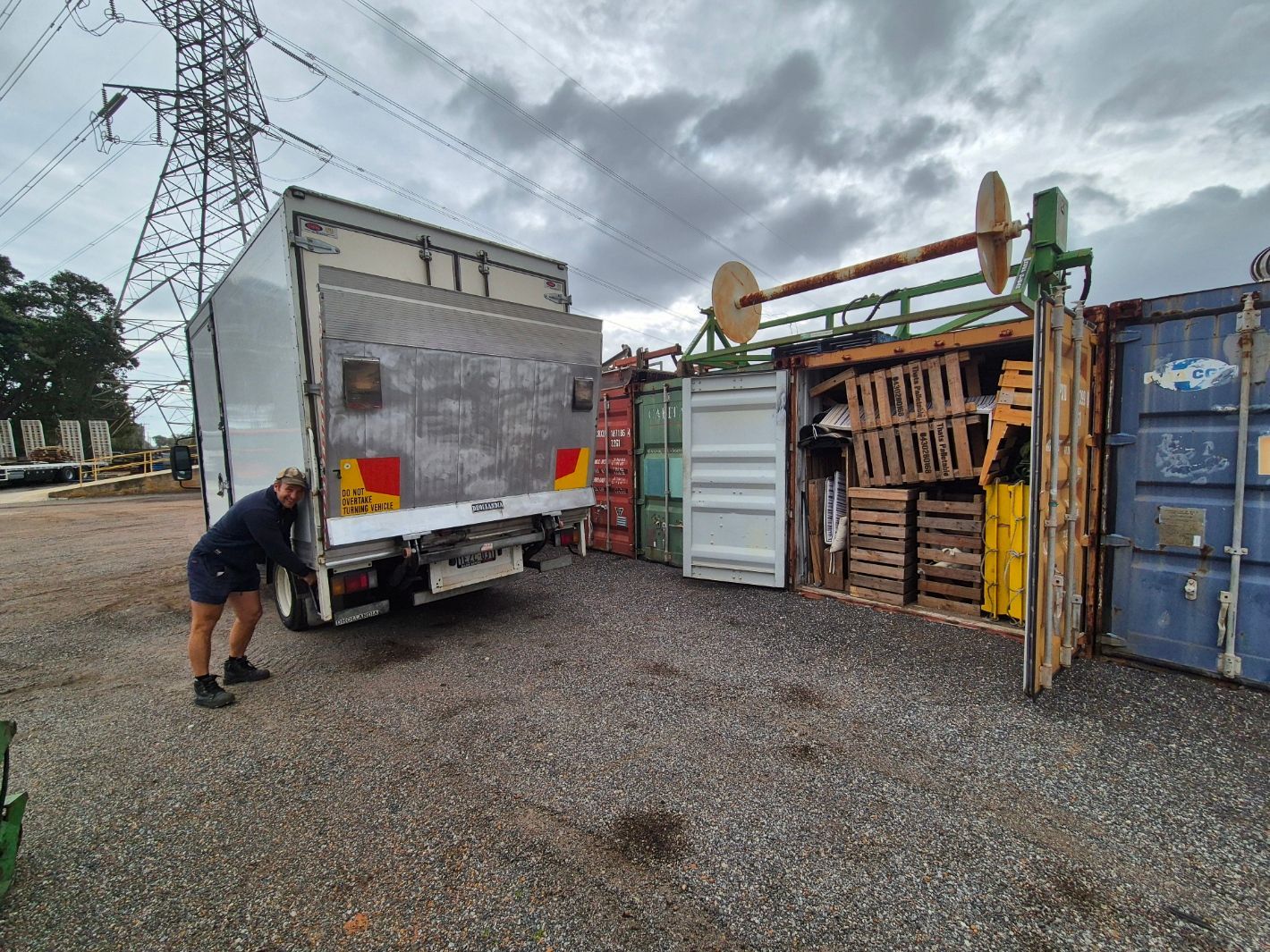 Back of a moving truck filled with furniture on a sunny day in a residential area.