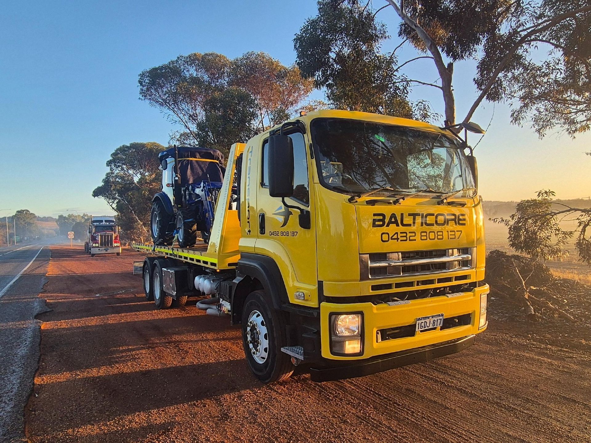 Back of a moving truck filled with furniture on a sunny day in a residential area.