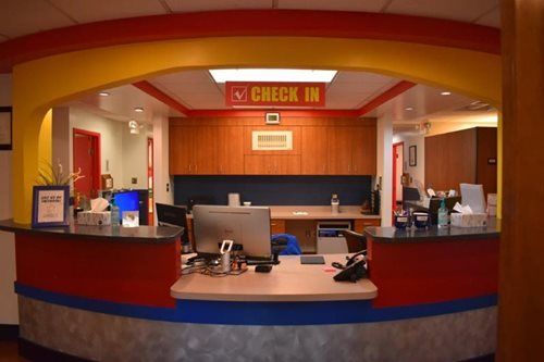 Hotel check-in desk with red archway, computers, and lobby counters