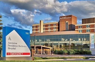 Aerials Pediatric Rehabilitation Hospital building with glass facade and red-brick tower under a cloudy sky