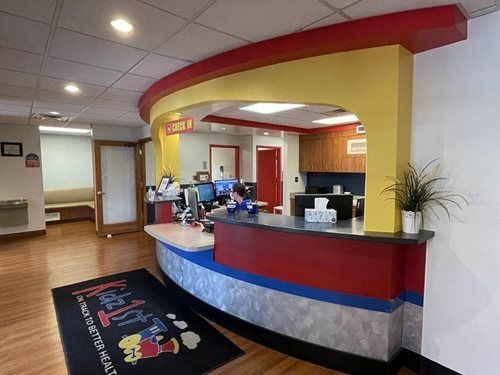 Hotel lobby with curved red-and-cream reception desk and seating area