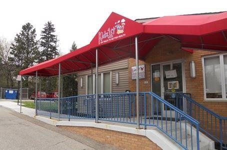 Exterior of Southeast Denver Pediatrics building with a sign and parked cars.