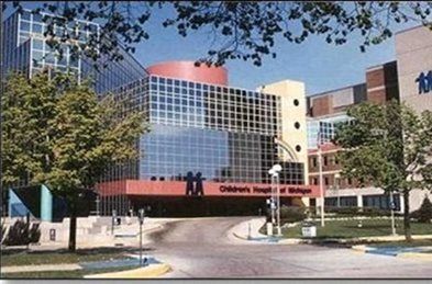Children's Hospital of Alabama entrance with glass facade, red canopy, and tree-lined driveway