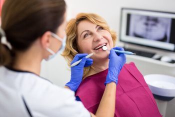 A Dental Professional in a Mask and Blue Gloves Examines a Patient's Teeth — Killara Dental in East Killara, NSW