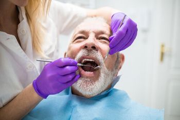 A Dental Professional in Purple Gloves Examines a Patient’s Teeth — Killara Dental in East Killara, NSW