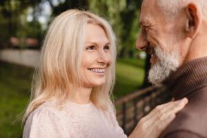 A Smiling Person Looks Affectionately at Their Partner in a Park — Killara Dental in East Killara, NSW