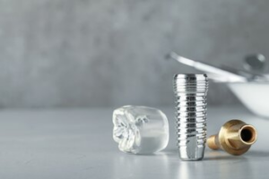 A Metal Dental Implant Screw, a Gold-colored Abutment — Killara Dental in East Killara, NSW