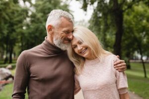 A Smiling Couple Embraces Outdoors in a Park — Killara Dental in East Killara, NSW