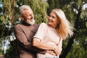 A Couple Embraces and Smiles at Each Other Outdoors — Killara Dental in East Killara, NSW