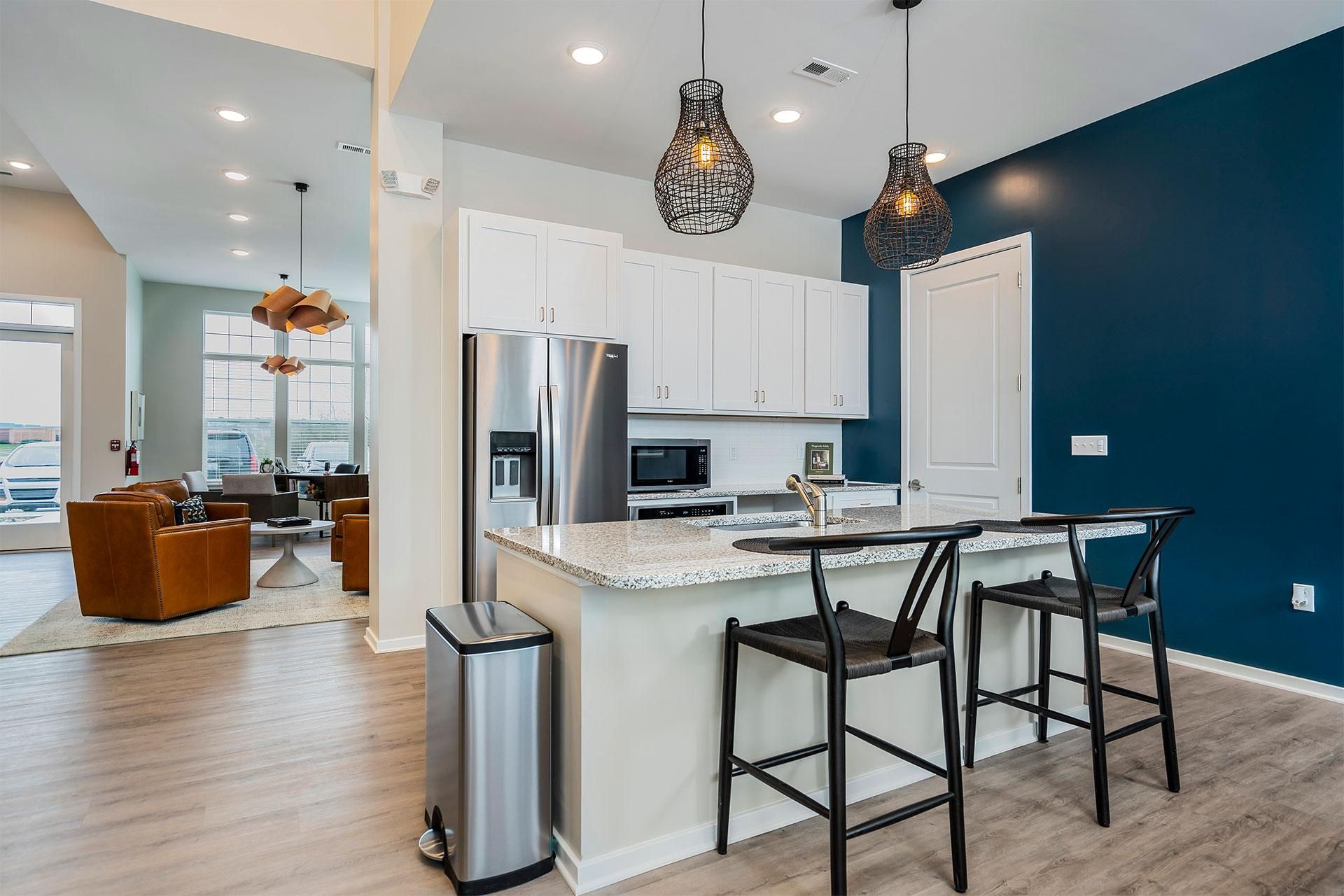 A kitchen with a bar stool and a bar counter.