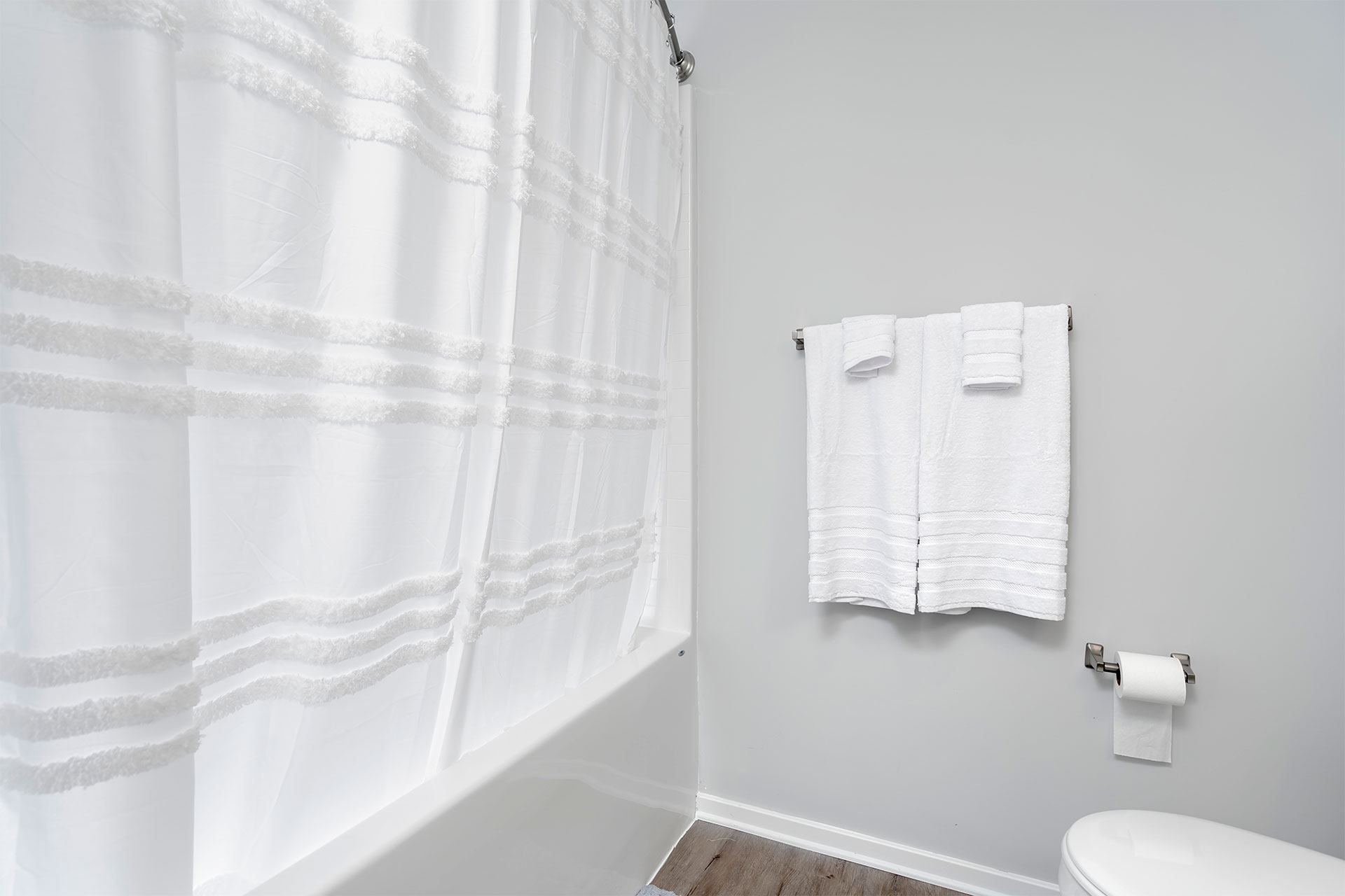 A white shower curtain in a bathroom.