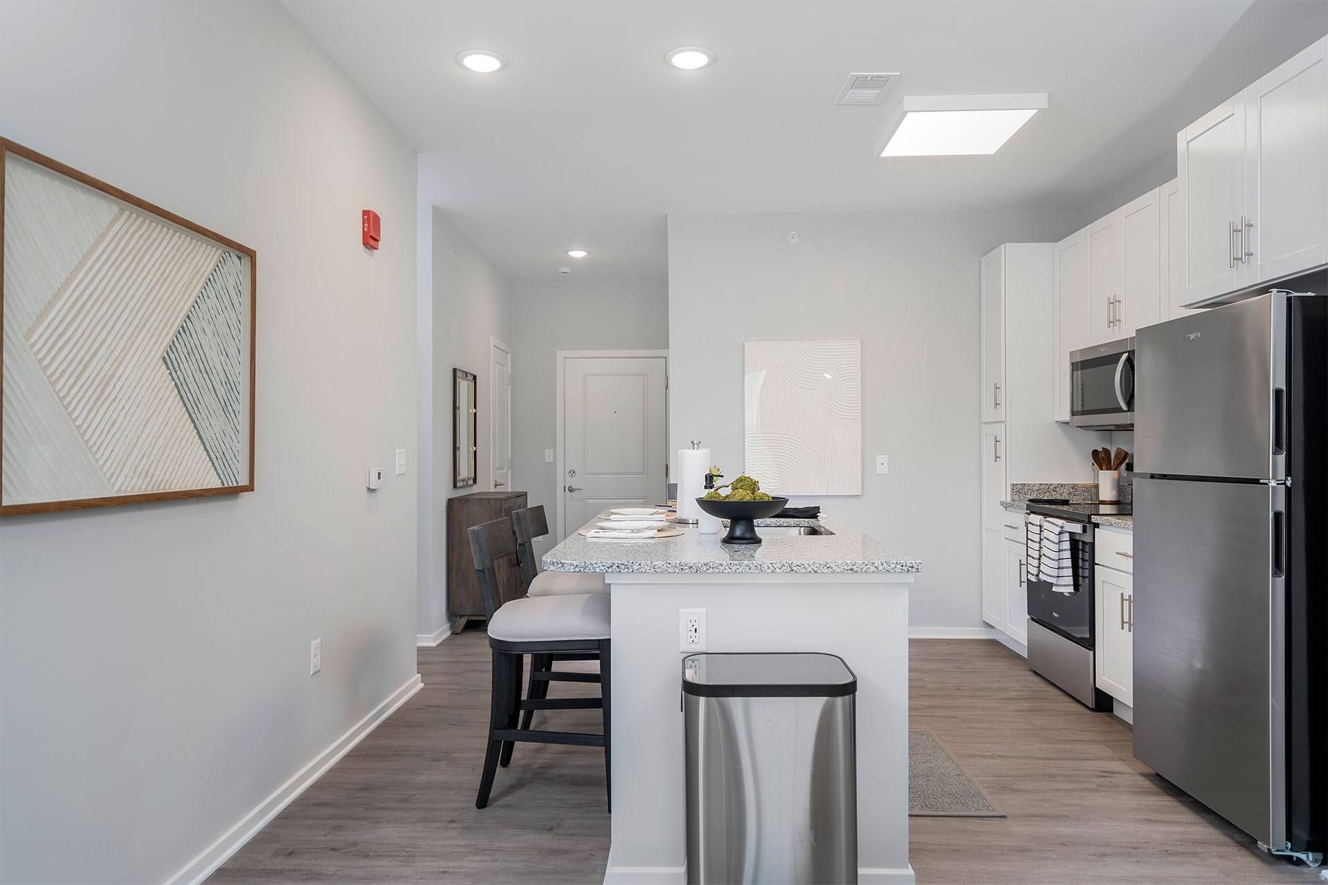 A kitchen with a white island and stainless steel appliances.