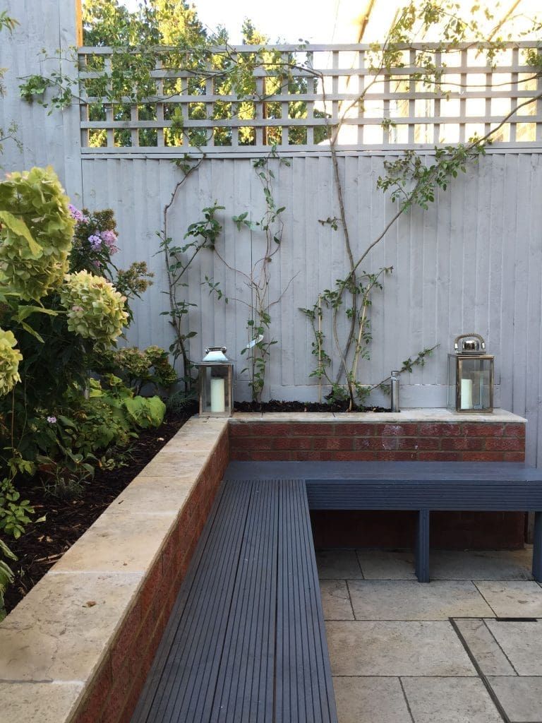 A backyard with grey painted fence