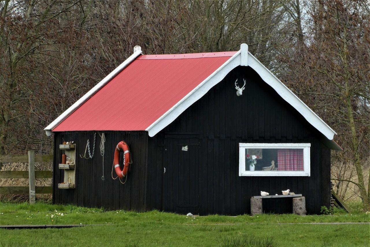 A black garden shed in a Reading home garden, expertly painted by Snowflake Decor.