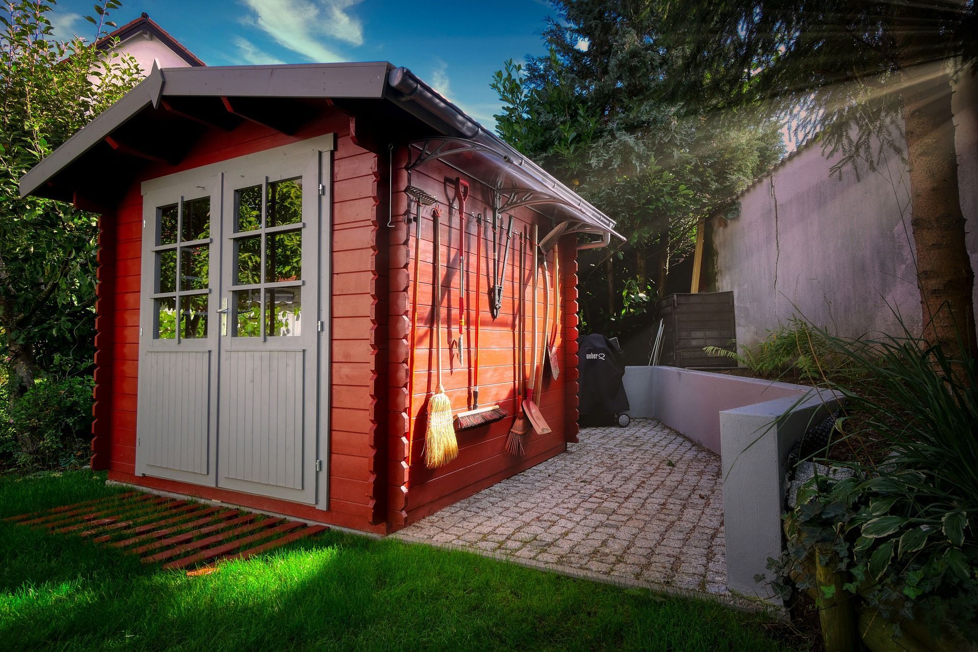 A red garden shed in a Reading home garden, expertly painted by Snowflake Decor.