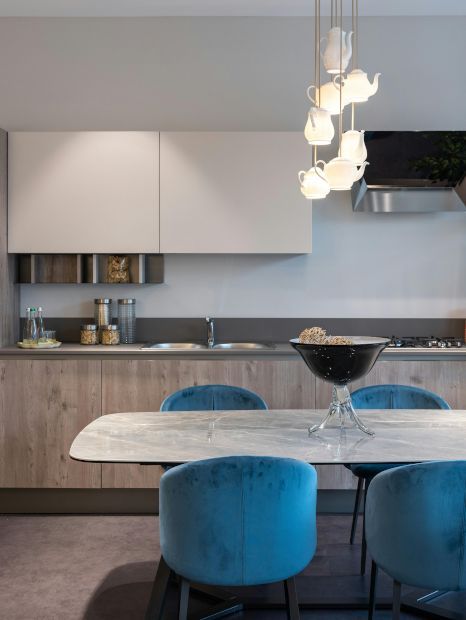 A kitchen with a marble table and blue chairs