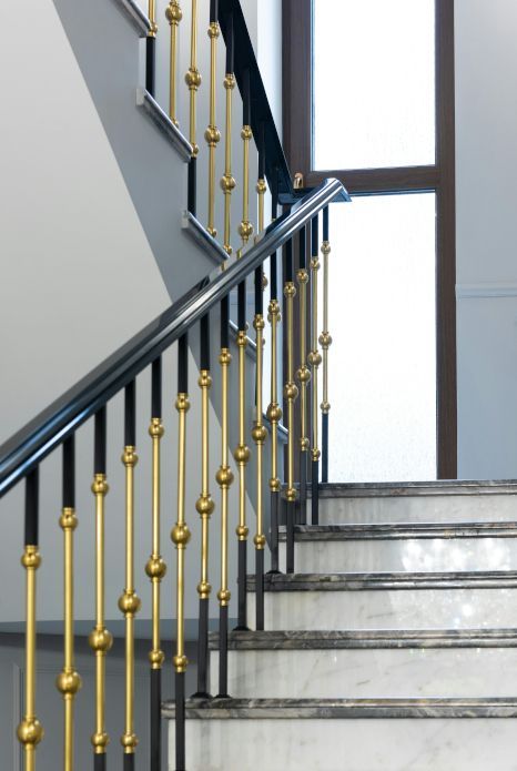 A staircase with a black railing and gold railings. Staircase expertly painted by Snowflake Decor in Reading, UK.