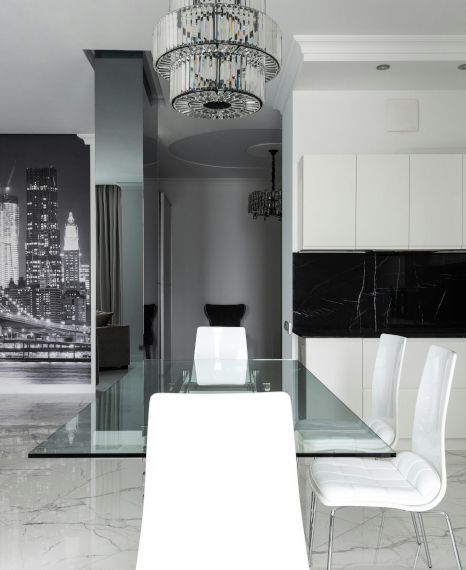 A dining room with a glass table and white chairs