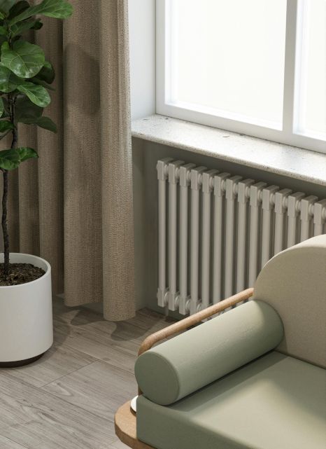 A living room with a chair , radiator , and potted plant.