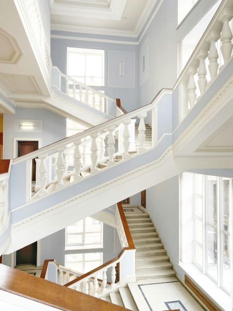 A large staircase in a building with lots of windows. Staircase expertly painted by Snowflake Decor in Reading, UK.