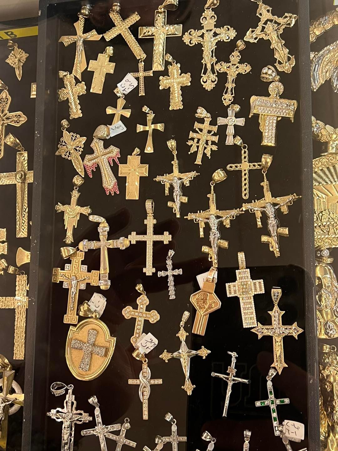 Display case filled with gold and silver cross pendants.