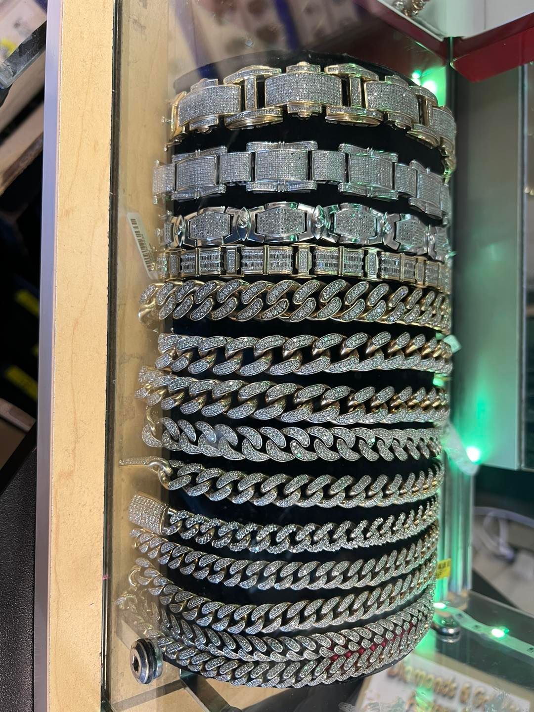 Gold and silver diamond bracelets displayed on a black surface.