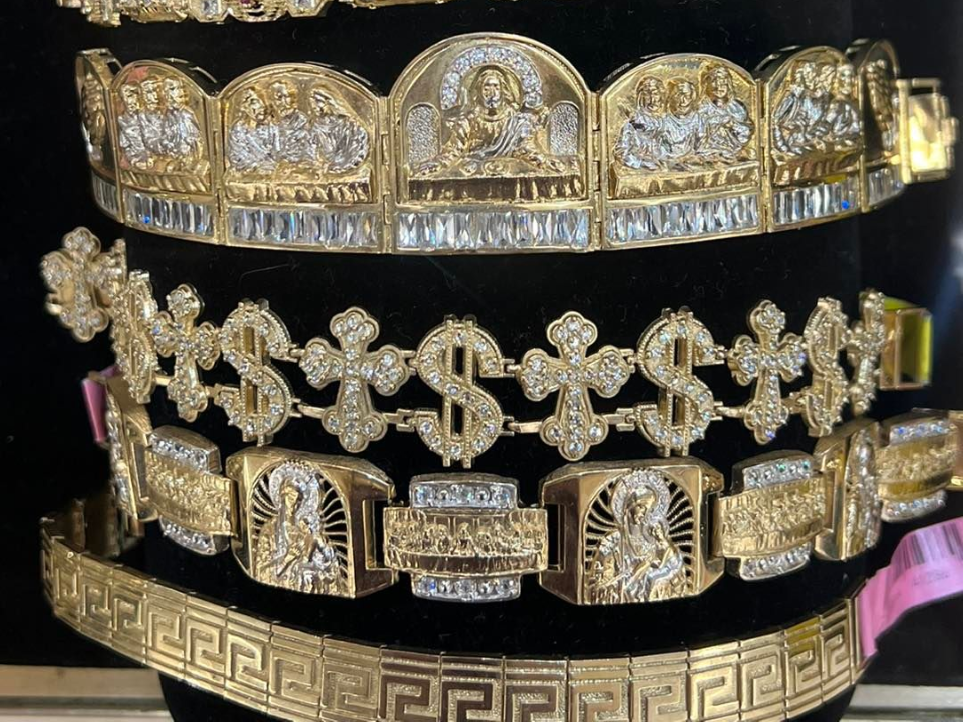 Gold jewelry: grill, bracelets, and necklace with religious and dollar sign designs in Fayetteville, NC.