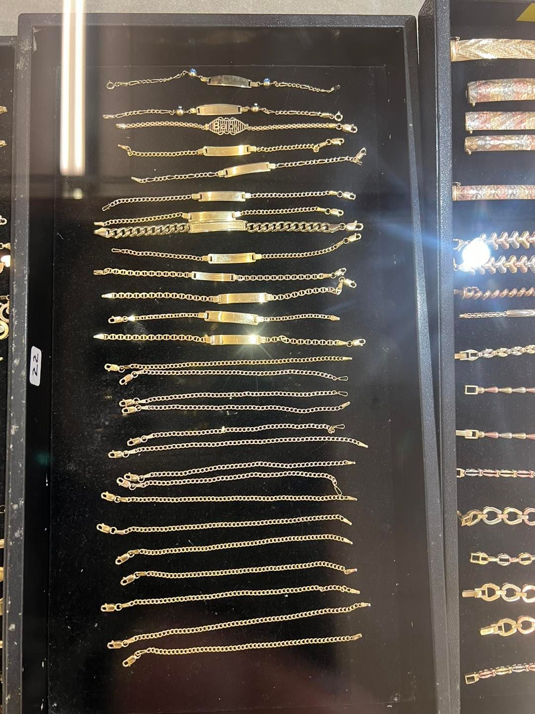 Gold bracelets displayed in a jewelry store case.