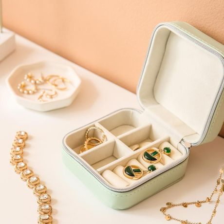 A jewelry box filled with rings and bracelets on a table