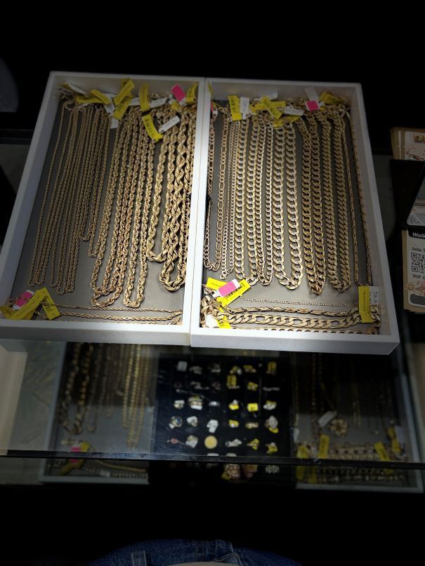 Display case filled with gold chain necklaces and earrings.