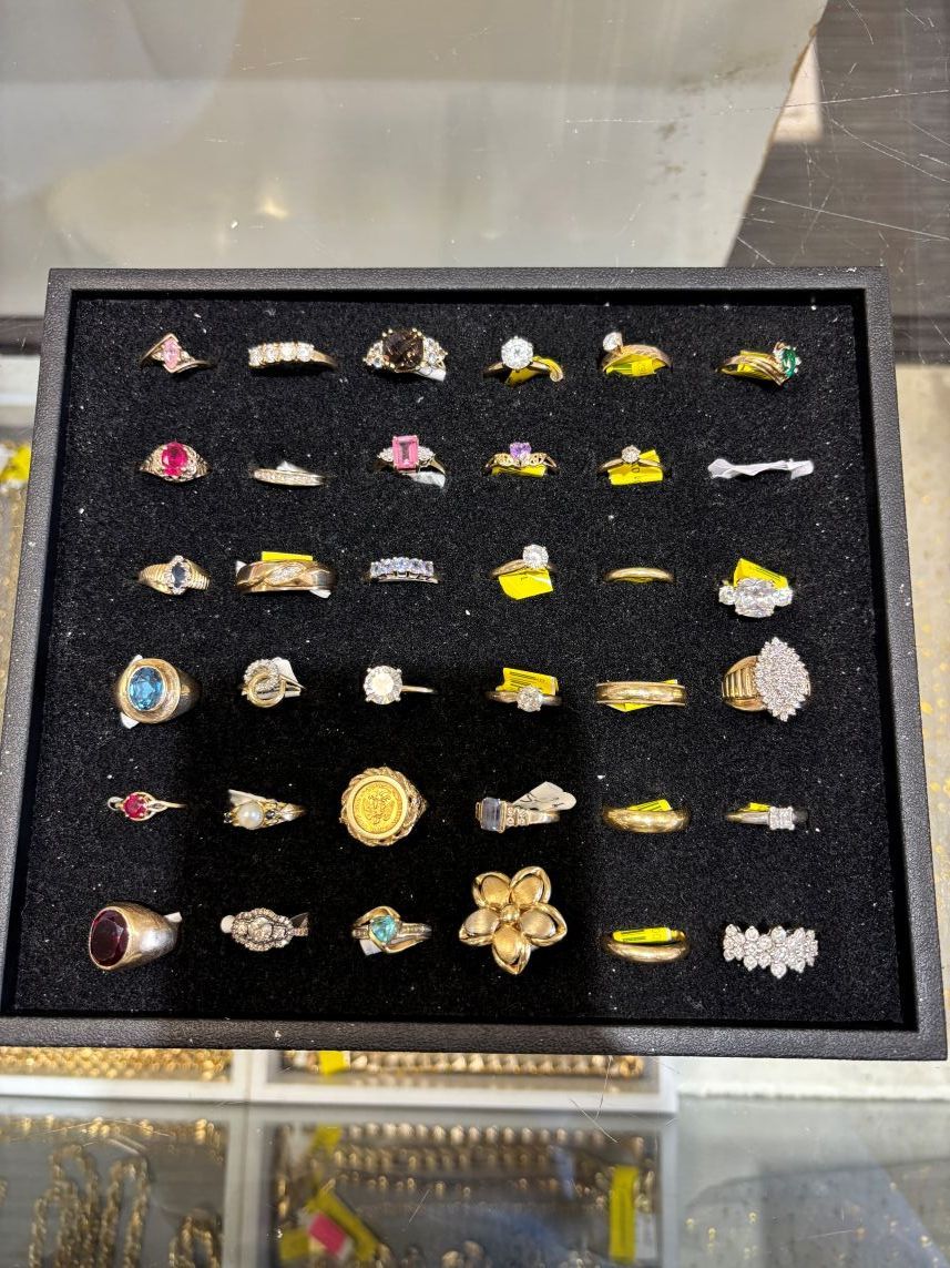 Black tray with display of numerous rings of various designs and colors.