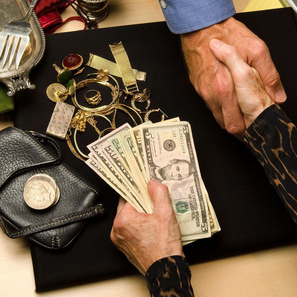 A man and woman shaking hands over a pile of money