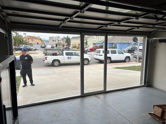 Close-up of a garage door track and hinge mechanism, bolted together with screws.