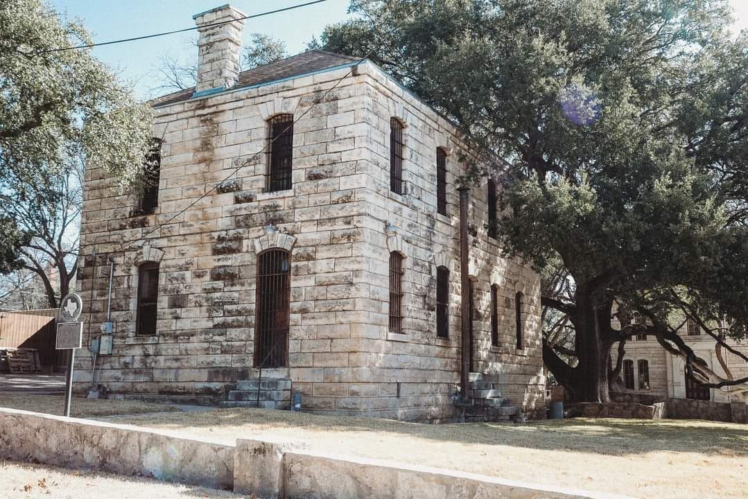 A large stone building with a tree in front of it.