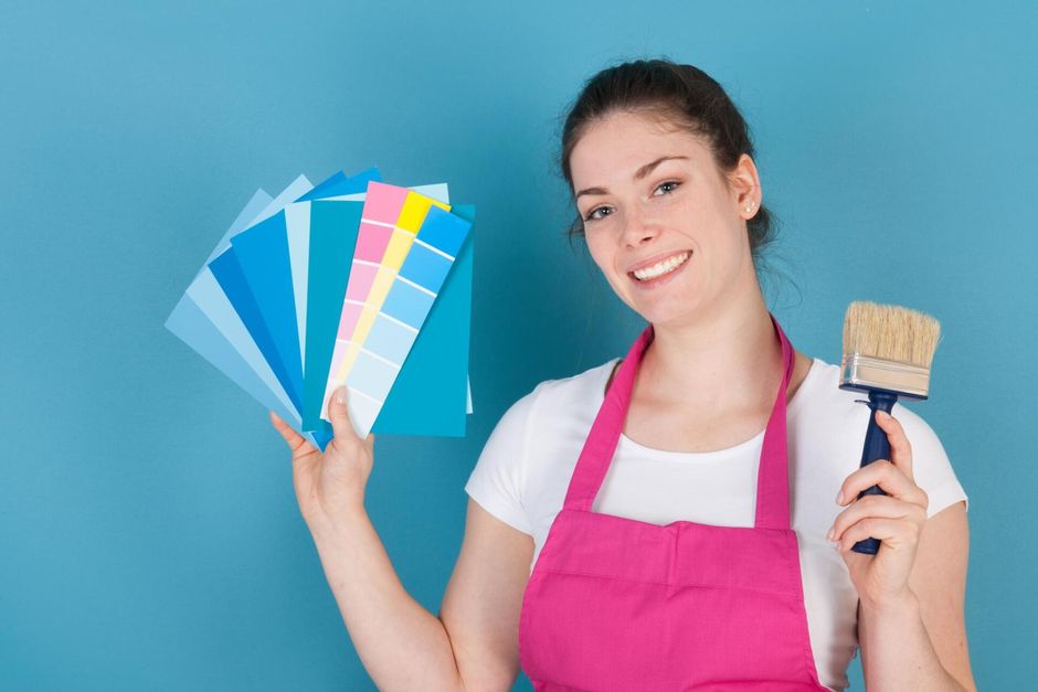 girl holding paint color choices and a brush