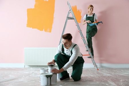 a man and a woman painting the wall