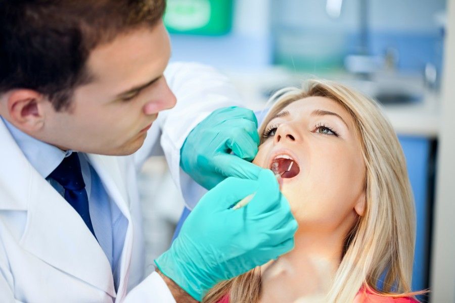 A Dentist is Examining a Woman Teeth in a Dental Office — ProCare Dental Australia in East Maitland, NSW