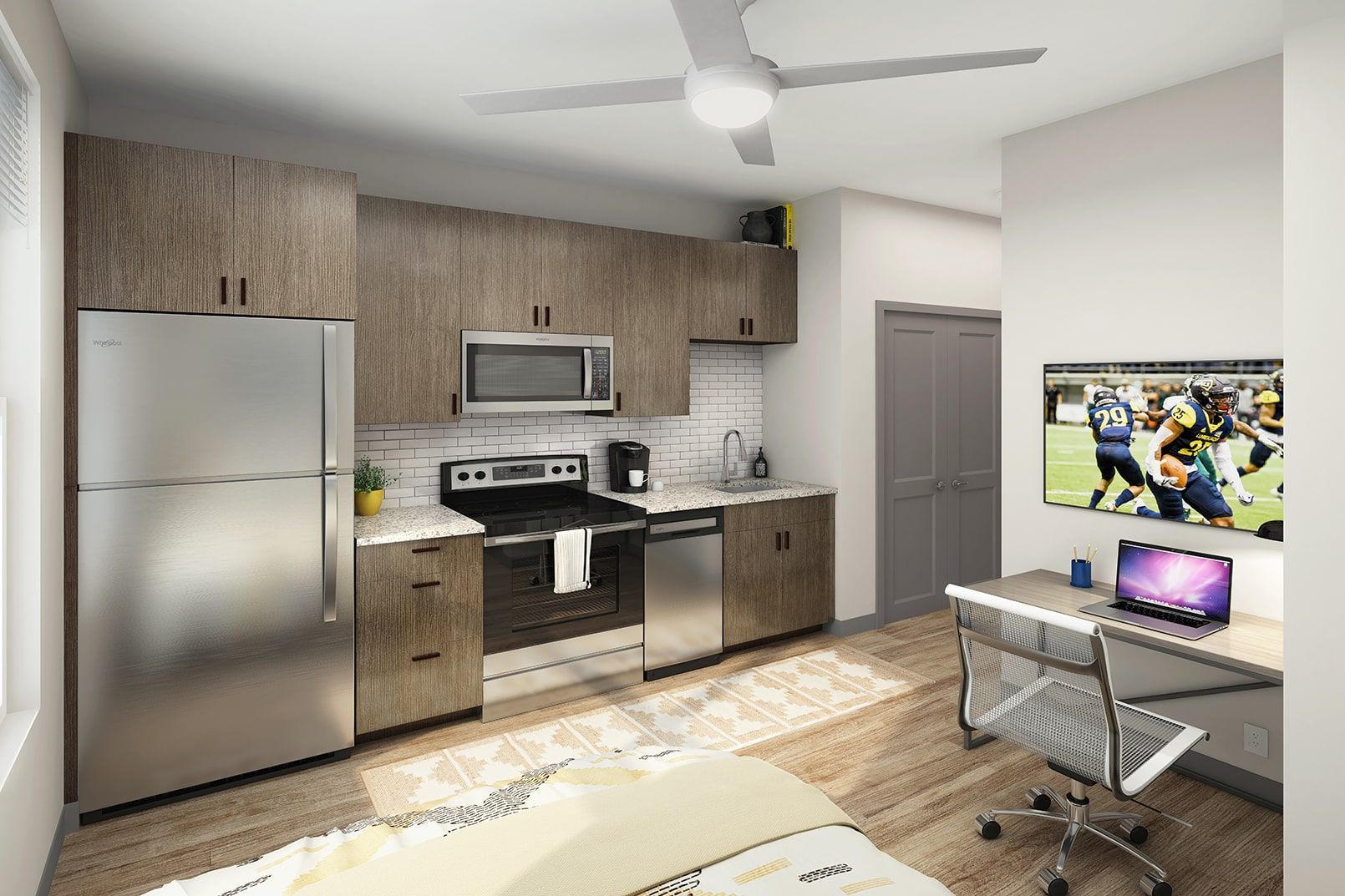 Modern apartment kitchen with stainless-steel appliances and a desk workspace.