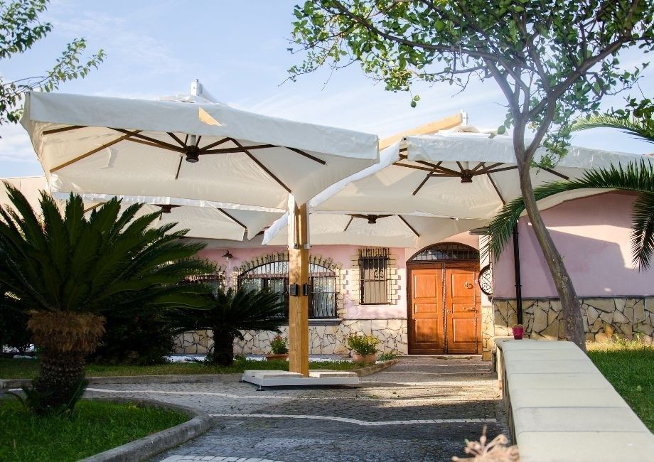 Due ombrelli bianchi sono appoggiati davanti a una casa