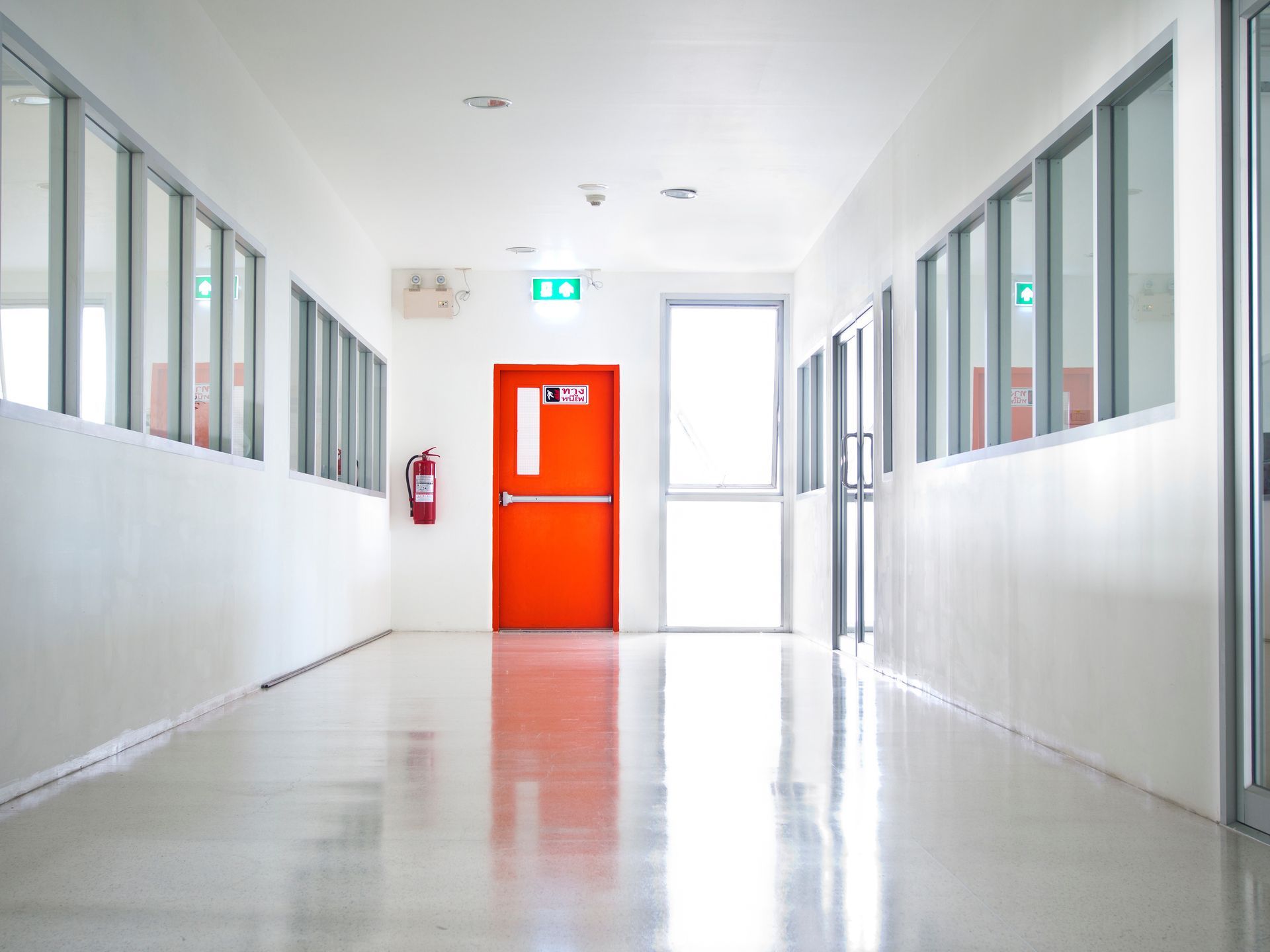 A red building emergency exit door with an exit sign