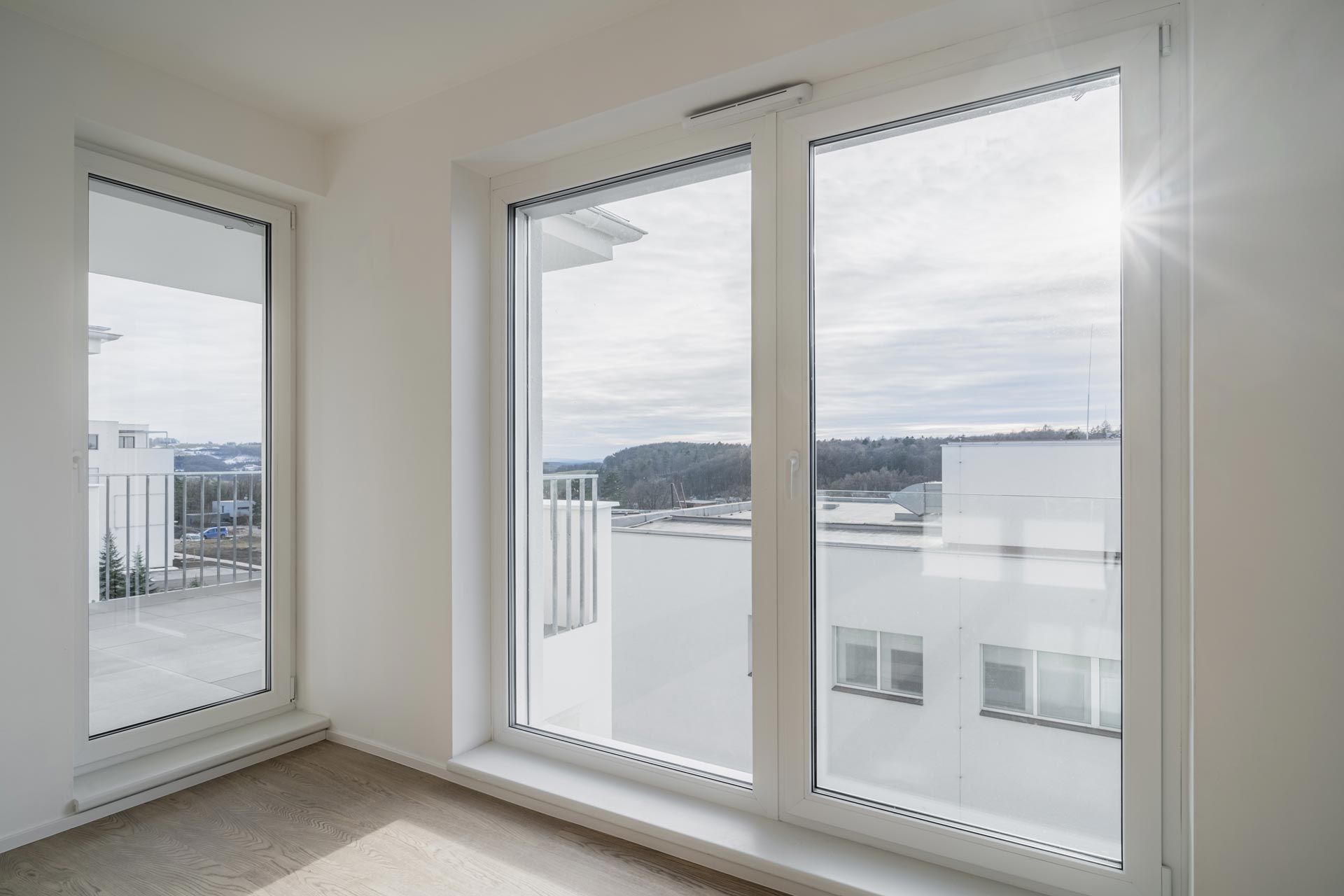 A room with large floor-to-ceiling double-glazed windows that offer a view of modern buildings. A room with large floor-to-ceiling double-glazed windows that offer a view of modern buildings.