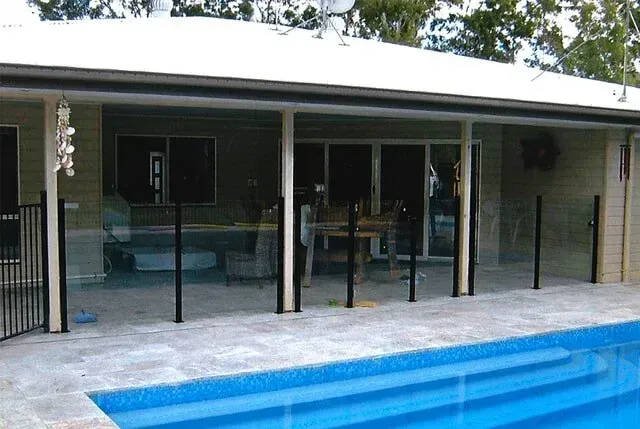 A Swimming Pool Surrounded By A Glass Fence — Rockhampton Powdercoating & Fence Panels in Park Avenue, QLD