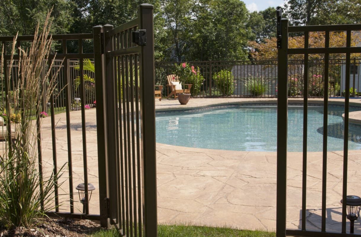 A Swimming Pool Surrounded By A Fence — Rockhampton Powdercoating & Fence Panels in Park Avenue, QLD