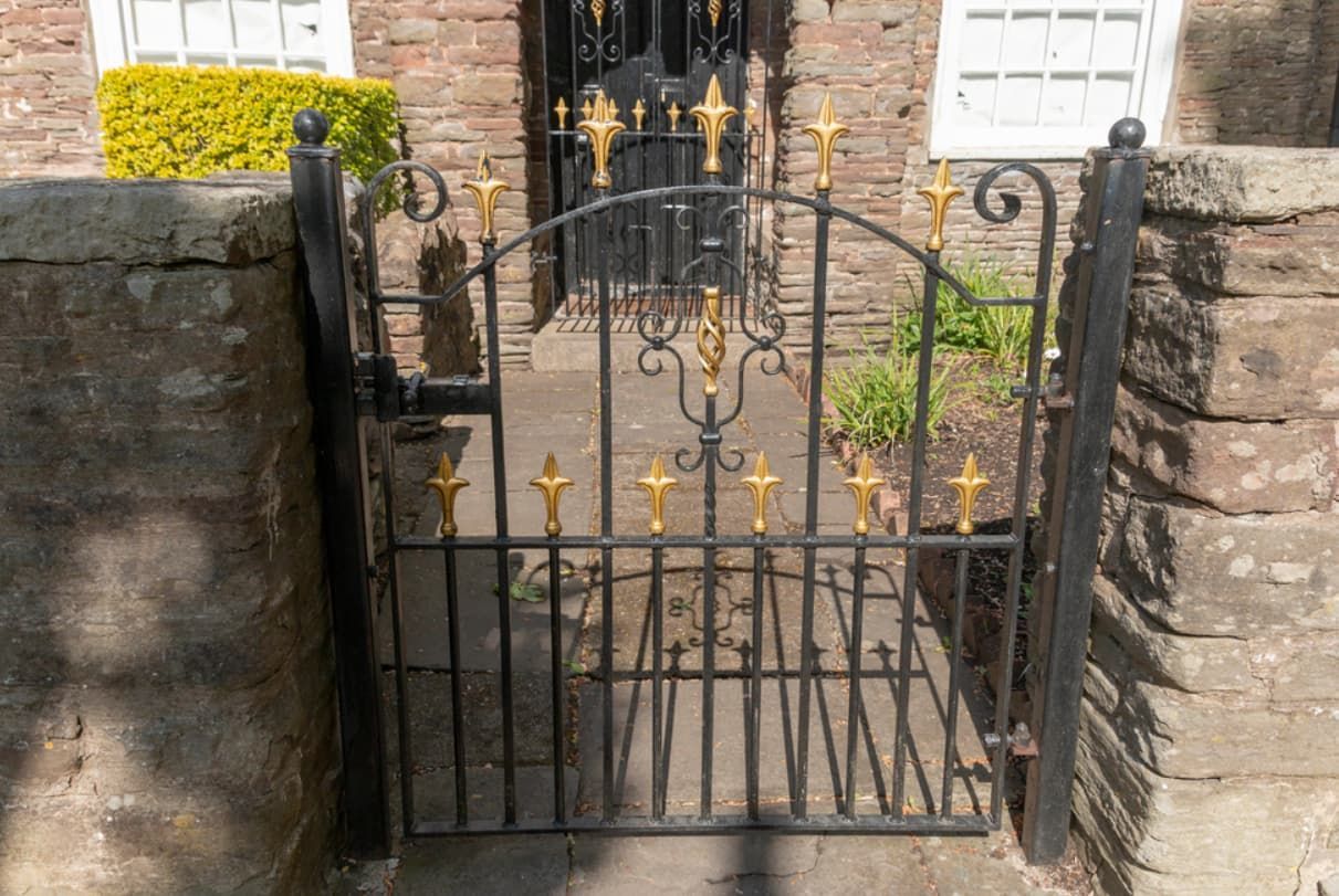 A Wrought Iron Gate With Gold Crosses On It Is — Rockhampton Powdercoating & Fence Panels in Park Avenue, QLD