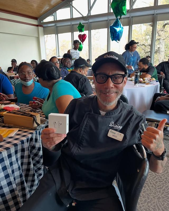 Loyola staff member showing the prize he won and giving a thumbs up.
