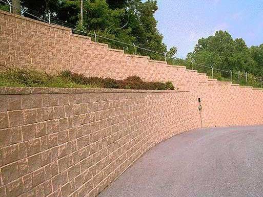 A large brick wall along the side of a road.