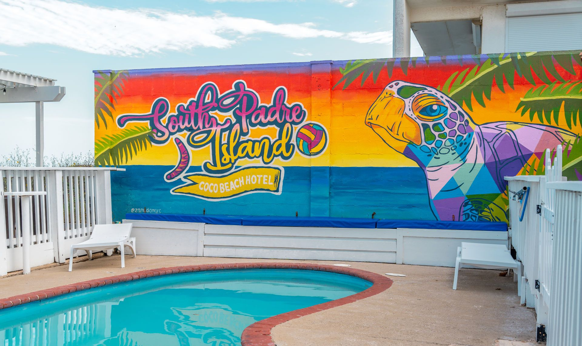 Poolside mural at South Padre Island with colorful turtle and text.