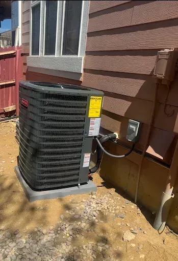 An air conditioning unit next to a building, with a yellow energy guide label.