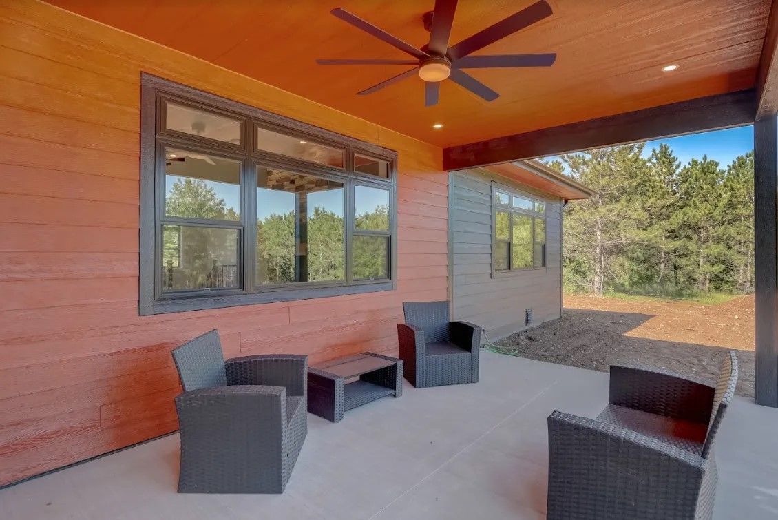 A patio with chairs , a table and a ceiling fan.